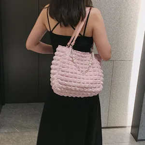 Detail of pink bubble textured tote bag with elegant pearl metal chain strap