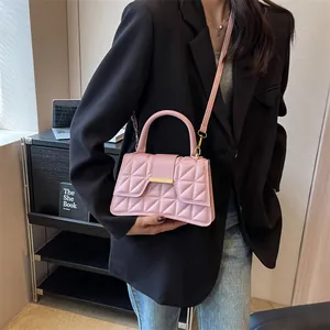Pink quilted crossbody bag with gold hardware worn by model in black blazer and jeans