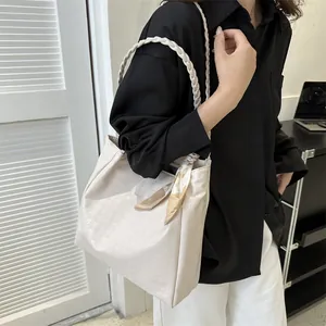 Chic beige houndstooth tote bag featuring a braided handle and decorative silk scarf detail