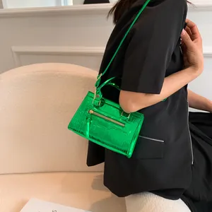 Detail of bright green crocodile texture leather bag with zipper and metallic finish