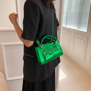 Green croc-effect crossbody bag featuring long tassels and gold-tone hardware details