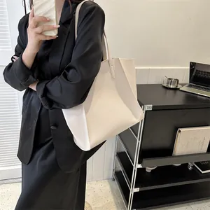 Bolso tote grande color crema combinado con americana negra para un look de oficina