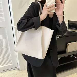 Bolso tote marfil minimalista combinado con un blazer negro para un look profesional