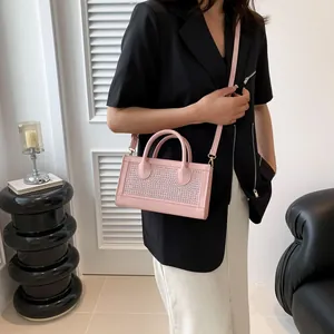 Detail of pink rhinestone handbag with dual handles and detachable shoulder strap
