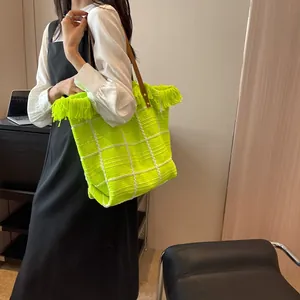 Détail du cabas en peluche vert fluo à carreaux avec franges et anses en cuir
