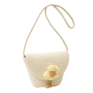 Women's woven flower bucket bag in cream with yellow daisy accessory and shoulder strap