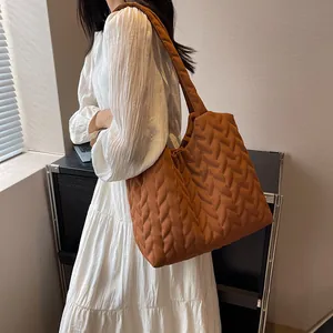 Detailed shot of brown quilted cloud tote bag with leaf-like stitching texture
