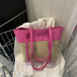 Detail einer Stroh-Einkaufstasche mit pinken Ledergriffen in einem Metall-Einkaufskorb