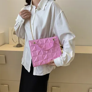 Détail du sac bandoulière rose géométrique 3D avec chaîne dorée et texture triangle
