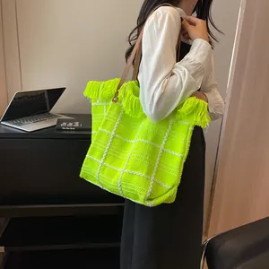 Détail du sac cabas en peluche à carreaux avec bordure à franges et bandoulière en cuir