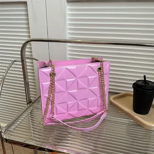Gros plan d'un sac à main rose texturé avec chaîne dorée sur une étagère moderne