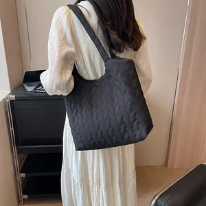 Detail of black quilted cloud tote bag with leaf-like texture and soft nylon shoulder strap