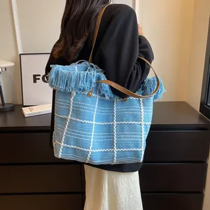 Vue détaillée du sac cabas en peluche à carreaux bleu clair avec franges et poignées