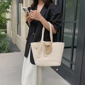 Detailed close-up of a woven basket bag with a beige lace bow and brown flap handle