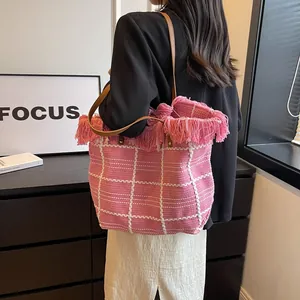 Sac fourre-tout rose à carreaux en peluche avec franges et bandoulière marron porté