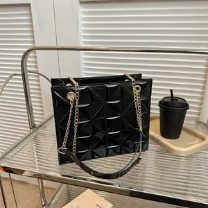 Détail d'un sac à bandoulière en cuir verni noir brillant avec motif matelassé 3D