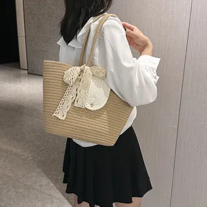 Close-up of woven straw tote bag featuring white lace bow and round magnetic pocket clasp