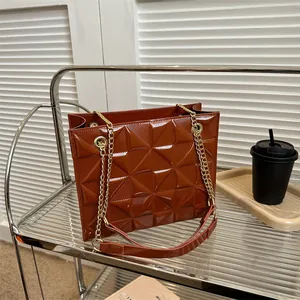 Gros plan détaillé du sac matelassé marron foncé brillant avec chaîne dorée chic