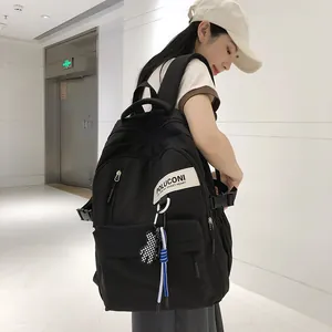 Détail du sac à dos en nylon noir avec pendentif ours à damier et boucles latérales
