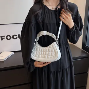 Dettaglio della borsa a mezzaluna bianca plissettata con trama trapuntata e modella