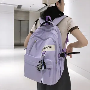 Détail du sac à dos en nylon violet clair avec poches zippées et charm ours peluche