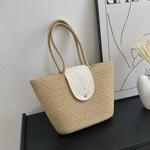Detailed close-up of a woven straw basket bag with a gold metal buckle and white flip cover