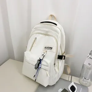 Détail du sac à dos crème minimaliste avec pendentif damier et cordon de décoration