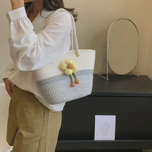 Détail du sac seau tissé avec fleur jaune et motif rayé pour la saison estivale
