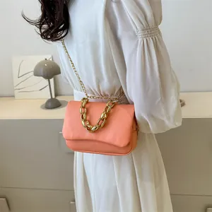 Vue détaillée du sac bandoulière orange corail avec poignée chaîne dorée et fine bandoulière