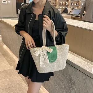 Handmade beige woven tote bag with green buckle and lace bow decoration for beach