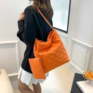 Detail of orange quilted tote bag with gold chain strap and matching small coin purse