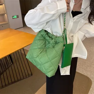 Detail of green quilted tote bag with puffer diamond pattern and chain strap