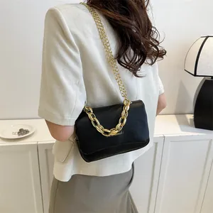 Détail du sac à bandoulière noir élégant avec chaîne dorée épaisse et bandoulière fine