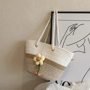 Détail d'un sac cabas tissé bicolore avec fleur 3D et poignées en corde de coton robuste