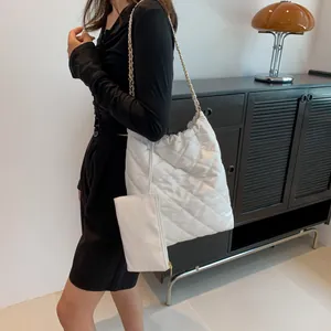 White quilted tote bag set with chain strap shown on model for a stylish casual look