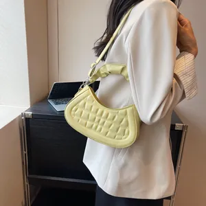 Borsa a mezzaluna trapuntata giallo chiaro minimalista con manico increspato su abito