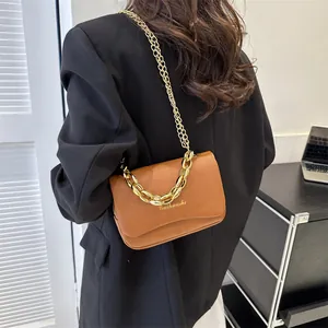Détail d'un sac à bandoulière marron en similicuir avec élégantes chaînes dorées