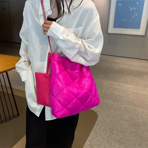 Bright pink quilted tote bag with golden chain strap and matching coin purse on model