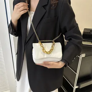 Sac bandoulière blanc rectangulaire avec chaîne dorée porté par un mannequin pour l'échelle