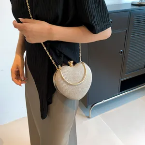 Detail of champagne gold heart clutch with glitter texture and round metal handle