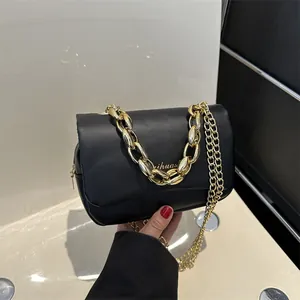 Détail du sac en similicuir noir avec poignée chaîne dorée et logo imprimé