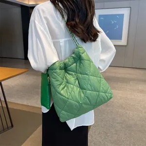 Green quilted large capacity tote bag with gold chain strap shown on model shoulder