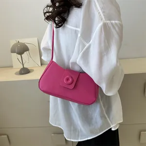 Detail of hot pink shoulder bag featuring a floral buckle and sleek minimalist strap