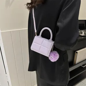 Detail of lavender checkered PU leather mini bag with plush monster charm on black suit