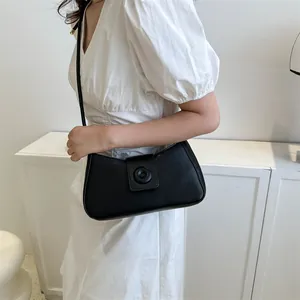 Close-up of minimalist black matte leather underarm bag with unique magnetic buckle