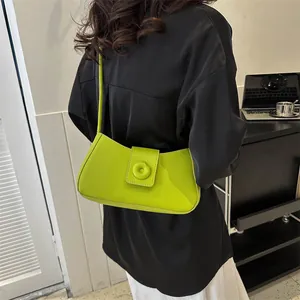 Neon green minimalist underarm bag shown with casual outfit in lifestyle setting