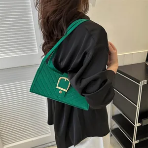 Detail of green felt shoulder bag with diagonal quilting and large gold square buckle