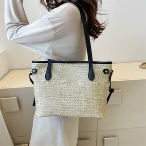 Elegante borsa tote in paglia intrecciata con manici in pelle nera e fibbie metalliche