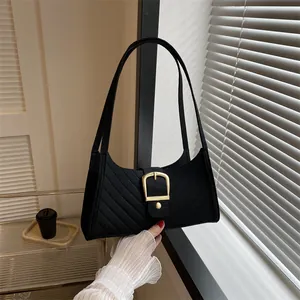 Detail of felt tote bag with diagonal stitching and a prominent gold buckle hardware