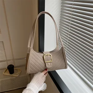 Detailed texture of beige felt fabric baguette bag with elegant quilted stripes and gold buckle